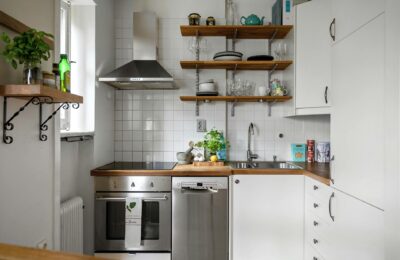 Contemporary small kitchen featuring stainless steel appliances and open shelving.