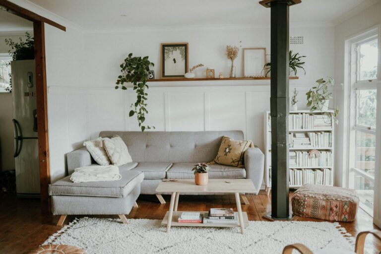 Bright and cozy living room with Scandinavian design and modern home decor, featuring a sofa and plants.