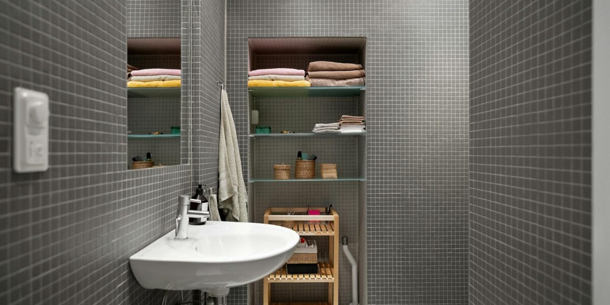 A sleek, modern bathroom showcasing minimalist design with functional shelving and clean aesthetics.