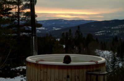 Cozy winter relaxation in a hot tub with stunning Norwegian mountain sunset views in Krøderen, Norway.