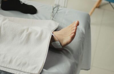 A close-up image of a bare foot with a medical electrode, suggesting a healthcare setting.