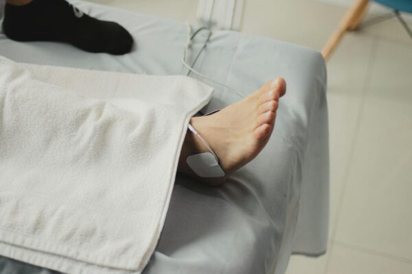 A close-up image of a bare foot with a medical electrode, suggesting a healthcare setting.