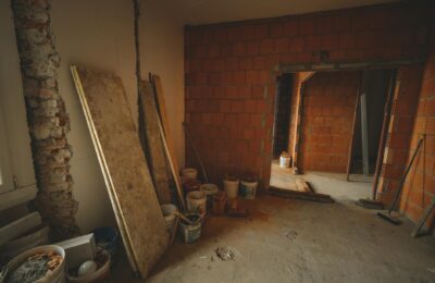 A red brick wall under construction with tools and materials scattered around in a renovation project.