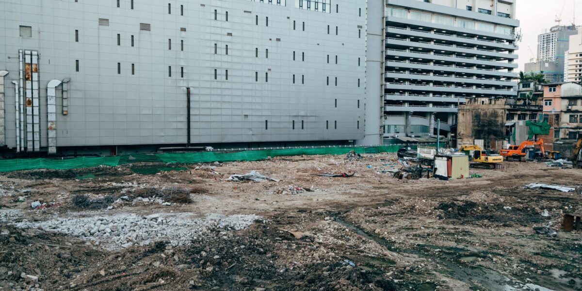 A construction site with surrounding modern buildings in an urban setting.