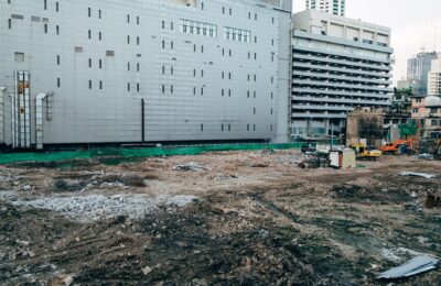 A construction site with surrounding modern buildings in an urban setting.