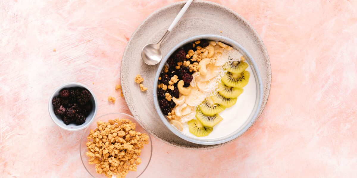 Delicious yogurt bowl topped with fresh kiwi, cashews, and mixed berries, perfect for a healthy breakfast.