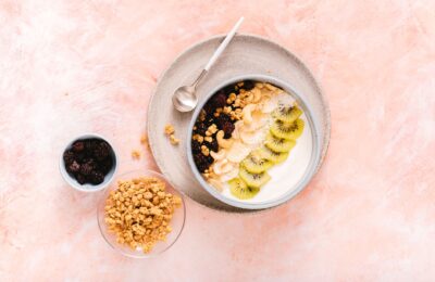 Delicious yogurt bowl topped with fresh kiwi, cashews, and mixed berries, perfect for a healthy breakfast.