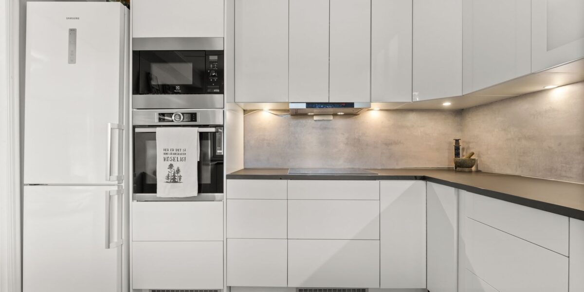 Sleek modern kitchen featuring white cabinetry, built-in appliances, and minimalist design.