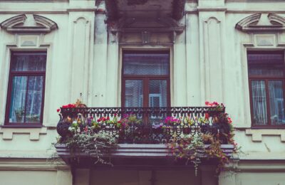 A beautiful vintage balcony adorned with colorful flowers and iron railing.