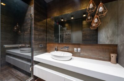 A sleek modern bathroom featuring pendant lighting and a contemporary sink.