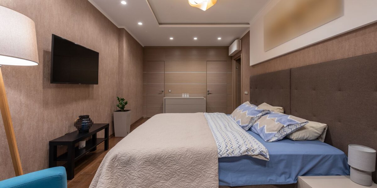 Elegant modern bedroom featuring a stylish bed, ambient lighting, and cozy decor.