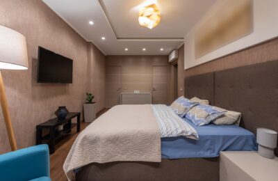 Elegant modern bedroom featuring a stylish bed, ambient lighting, and cozy decor.