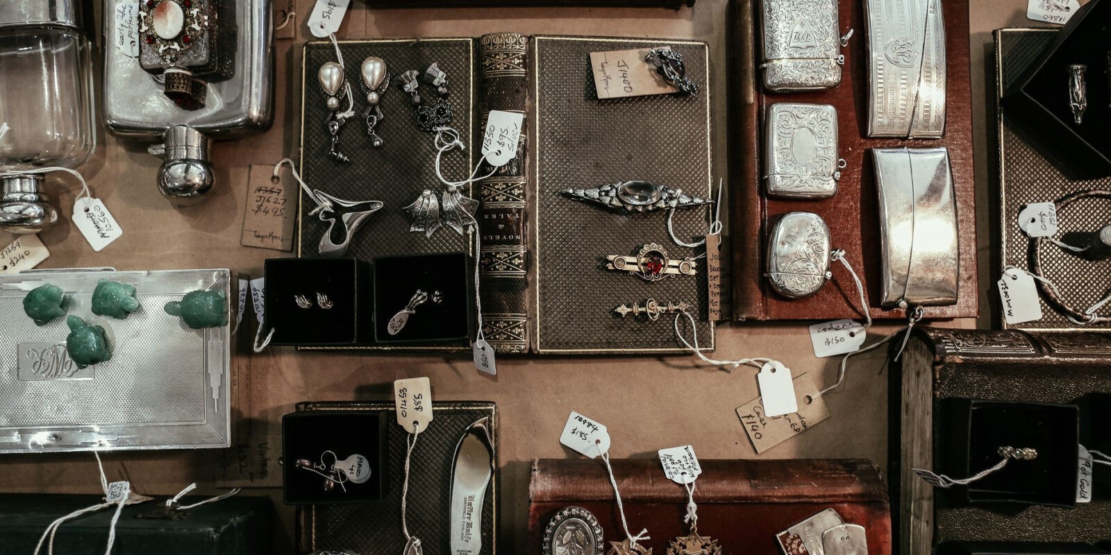 A curated selection of vintage and antique items on a display, including jewelry, books, and decorative pieces.