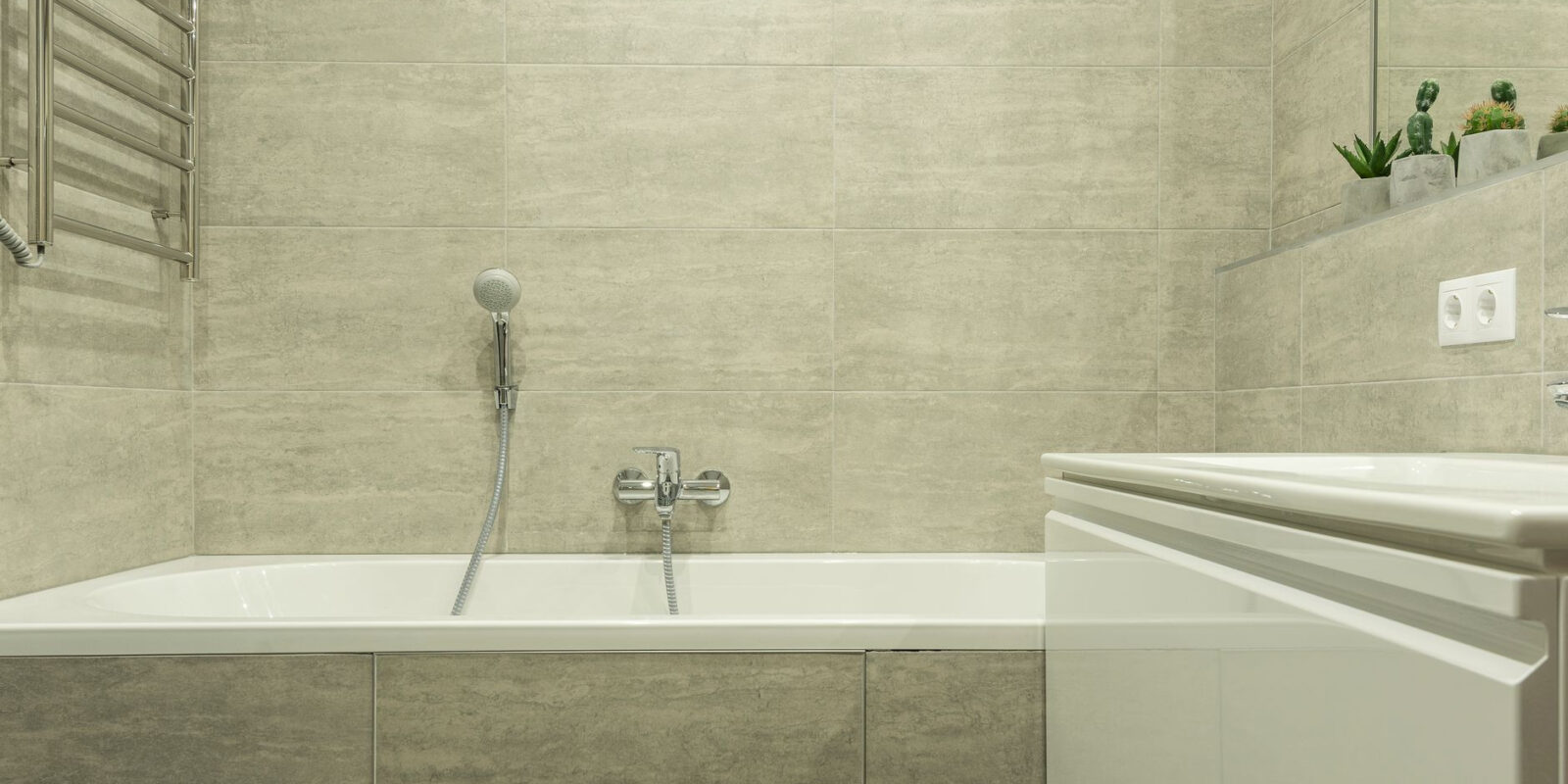 A clean and modern bathroom interior showcasing a ceramic bathtub and stylish tiles.