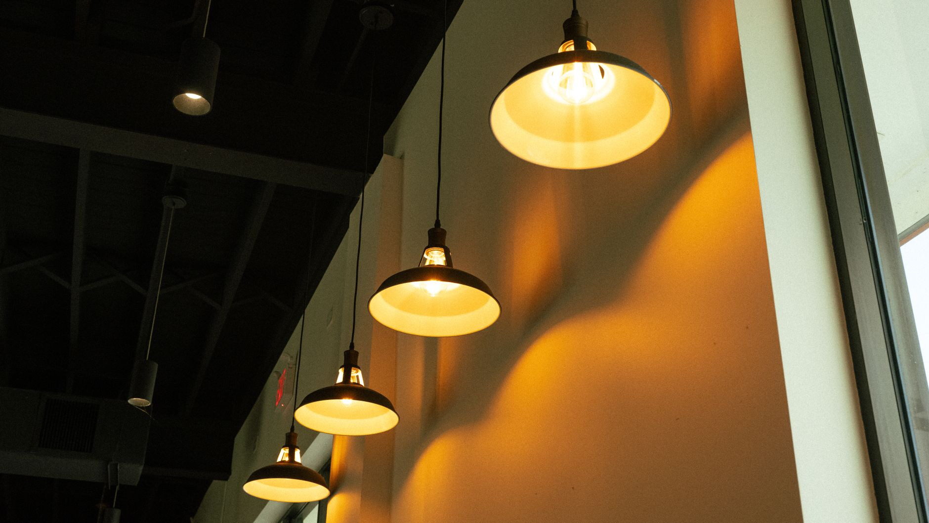 An array of pendant lamps casting a warm glow in a modern indoor setting.